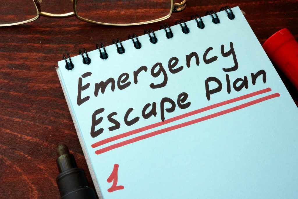 Evacuation Planning Emergency Escape Plan written on a notepad with marker.