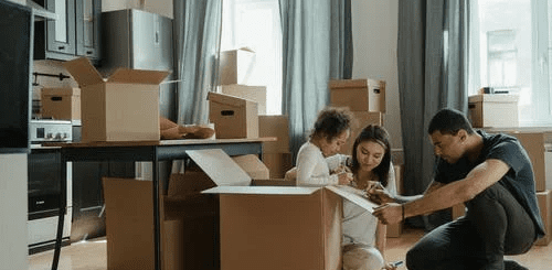 Young Family with Moving Boxes in New Home