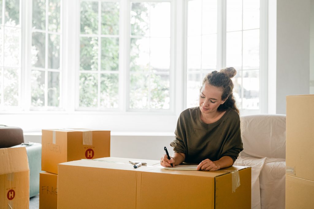 Young Woman Labeling Boxes
