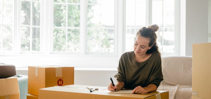 Young Woman Labeling Boxes