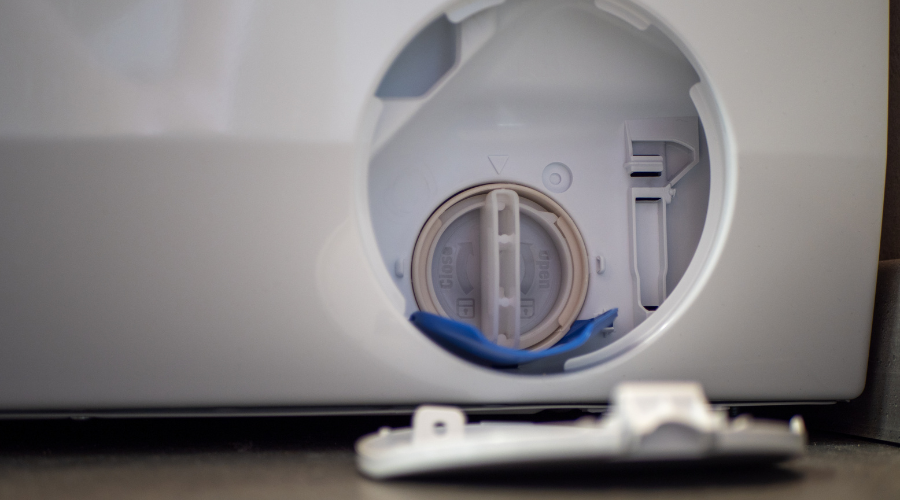 Open filter cover of washing machine. Dirty drain filter of the washing machine. Drain filter plug