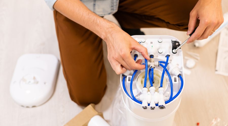 man fixing water softener to stop the leak